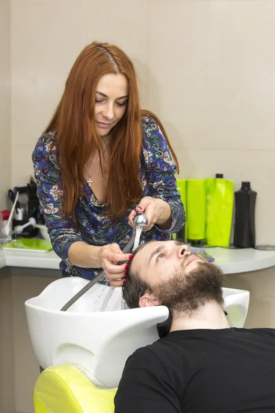 Parrucchiere femminile che taglia i capelli del cliente al salone — Foto Stock