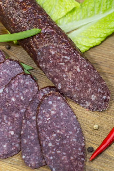 Sausage on a wooden plate — Stock Photo, Image