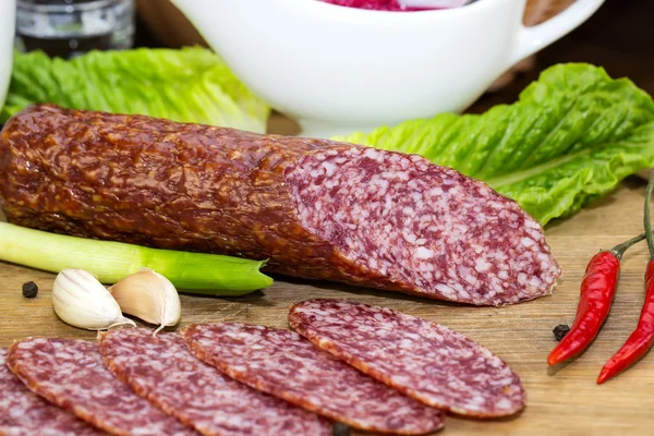 Sausage on a wooden plate — Stock Photo, Image