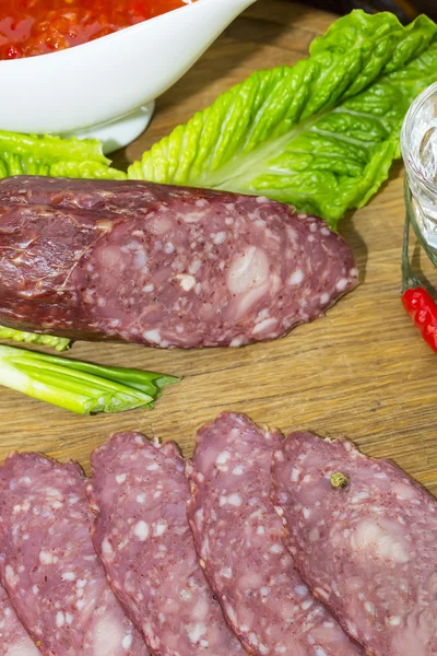 Saucisse sur une assiette en bois — Photo