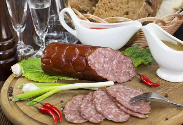 Sausage on a wooden plate — Stock Photo, Image