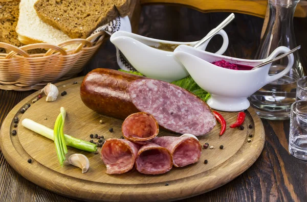 Sausage on a wooden plate — Stock Photo, Image