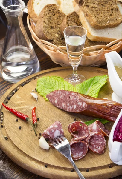 Sausage on a wooden plate — Stock Photo, Image