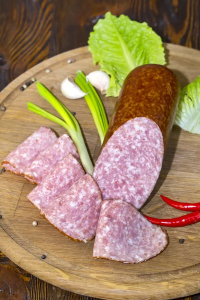 Sausage on a wooden plate — Stock Photo, Image