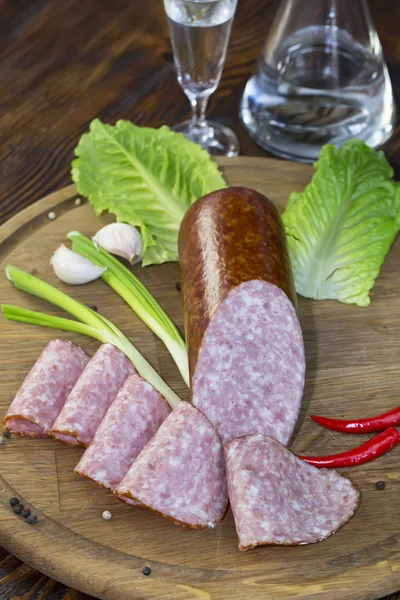 Sausage on a wooden plate — Stock Photo, Image