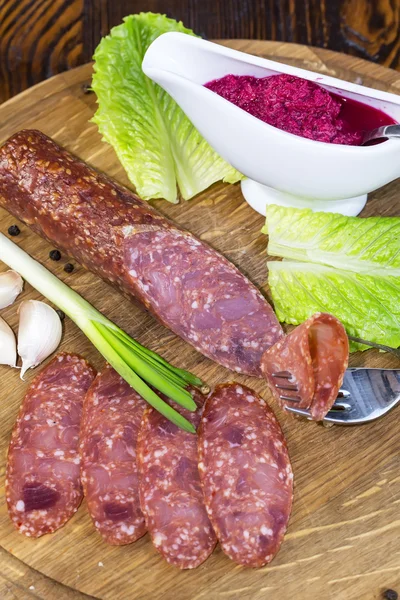 Saucisse sur une assiette en bois — Photo