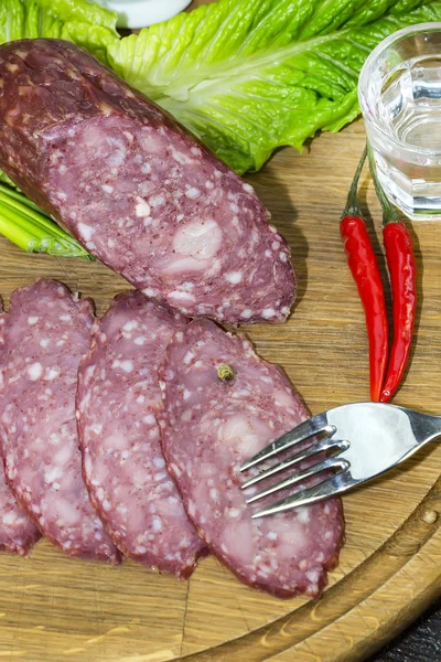 Sausage on a wooden plate — Stock Photo, Image