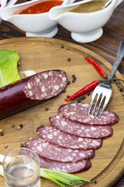 Sausage on a wooden plate — Stock Photo, Image