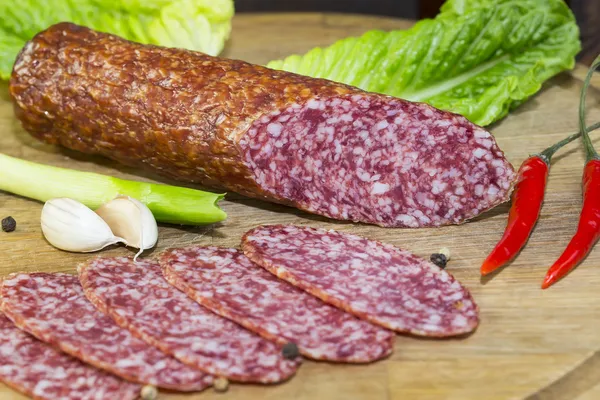 Sausage on a wooden plate — Stock Photo, Image