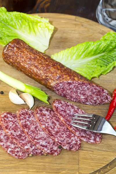 Sausage on a wooden plate — Stock Photo, Image