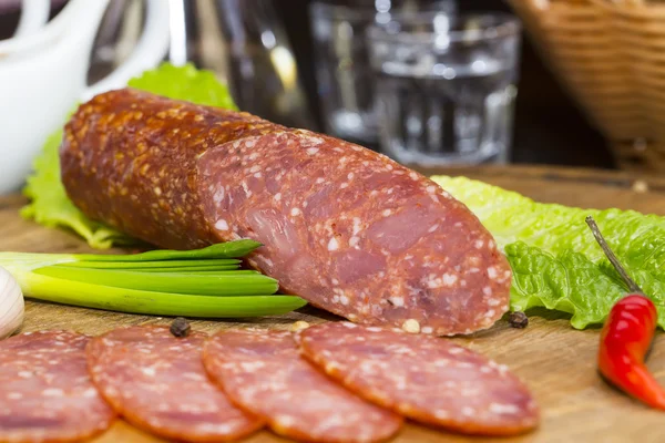 Salsiccia su un piatto di legno — Foto Stock