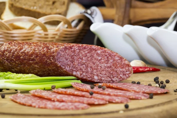 Sausage on a wooden plate — Stock Photo, Image