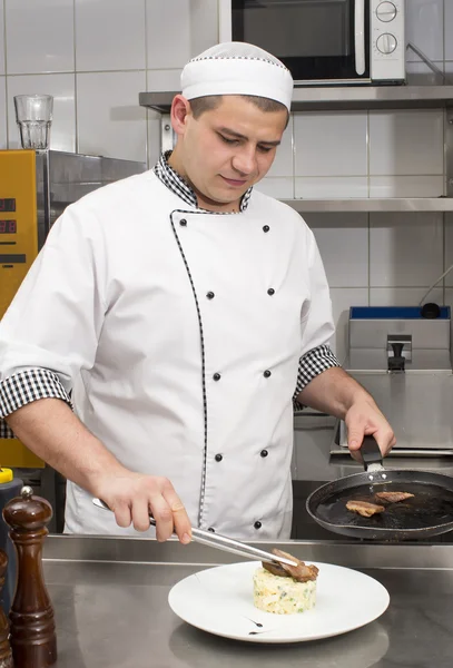 Koch bereitet Essen in der Küche zu — Stockfoto