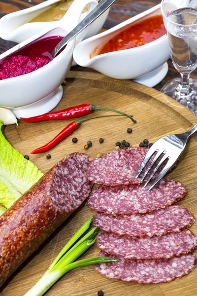 Sausage on a wooden plate — Stock Photo, Image