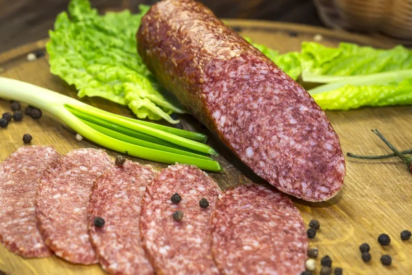 Salsiccia su un piatto di legno — Foto Stock