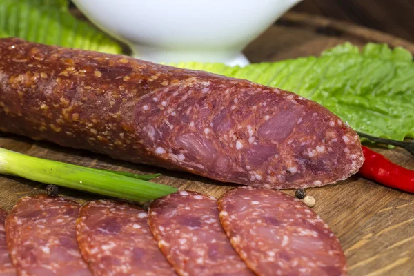 Sausage on a wooden plate — Stock Photo, Image