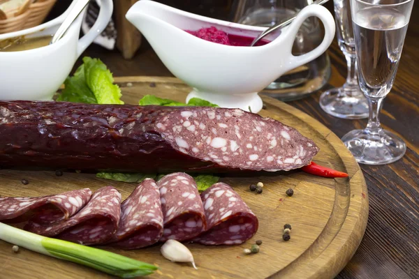 Sausage on a wooden plate — Stock Photo, Image