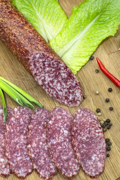 Sausage on a wooden plate — Stock Photo, Image