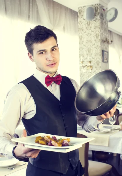 Kellner mit einem Tablett voller Essen — Stockfoto