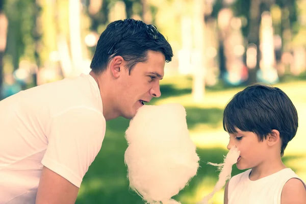 Pai e filho comendo algodão doce — Fotografia de Stock