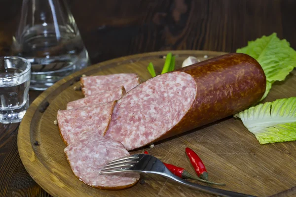 Sausages on a wooden plate — Stock Photo, Image