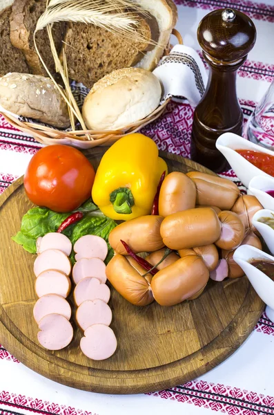 Sausages on a wooden plate — Stock Photo, Image