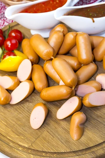 Sausages on a wooden plate — Stock Photo, Image