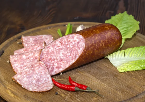 Sausages on a wooden plate — Stock Photo, Image