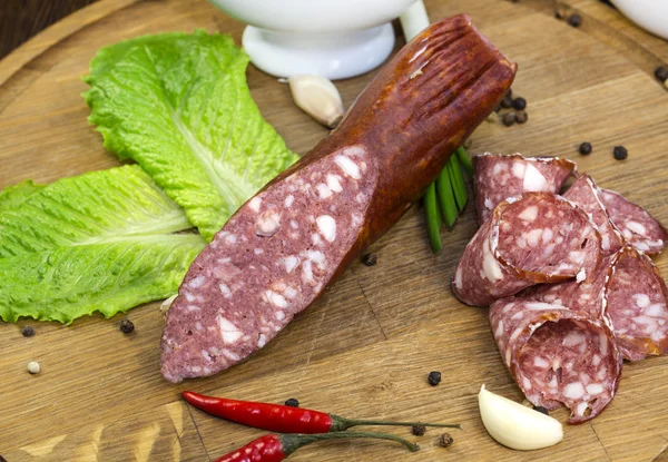 Sausages on a wooden plate — Stock Photo, Image