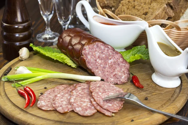 Sausages on a wooden plate — Stock Photo, Image