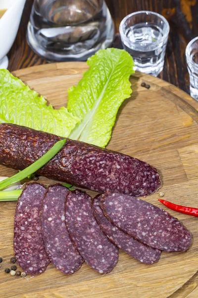 Sausages on a wooden plate — Stock Photo, Image