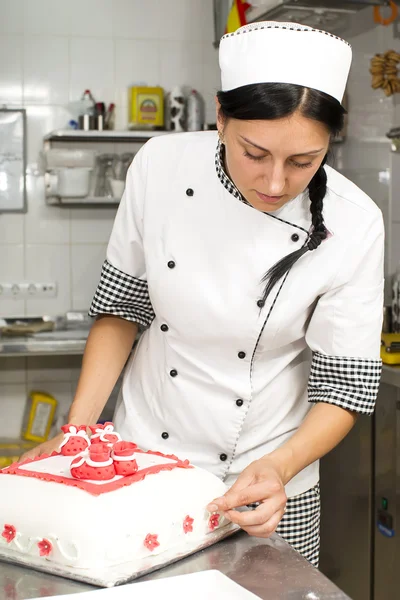 Chef de pastelaria decora um bolo — Fotografia de Stock