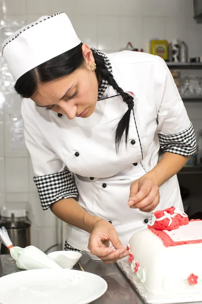 Pastry chef decorates a cake — Stock Photo, Image