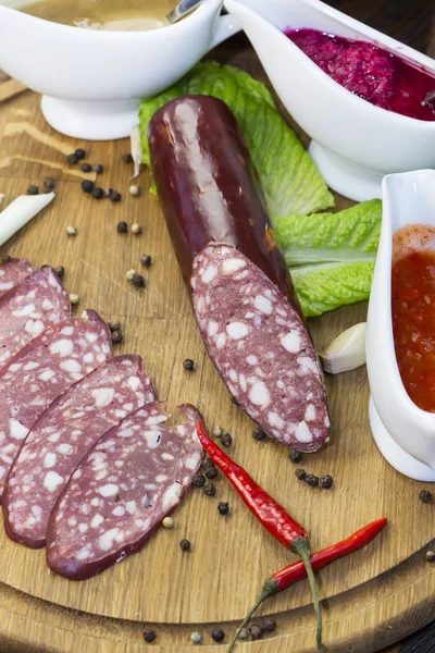 Saucisses sur une assiette en bois — Photo