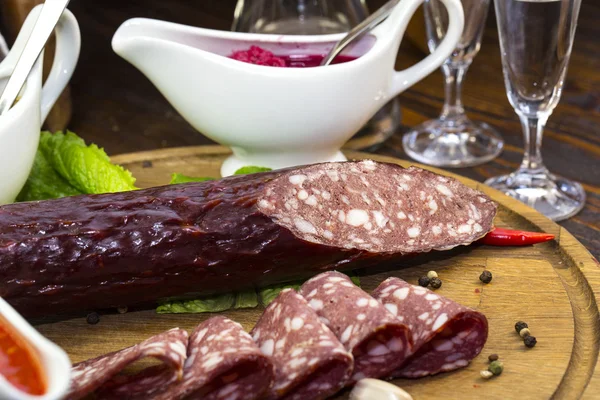 Sausages on a wooden plate — Stock Photo, Image