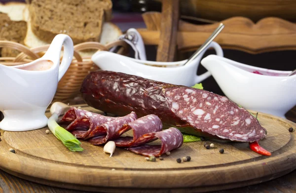 Sausages on a wooden plate — Stock Photo, Image