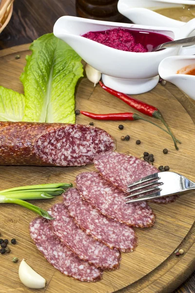 Sausages on a wooden plate — Stock Photo, Image