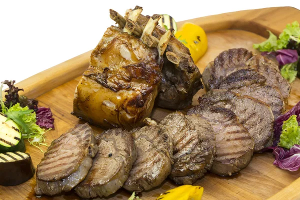 Fläskkarré och biff som tillagas på en grill med grönsaker — Stockfoto