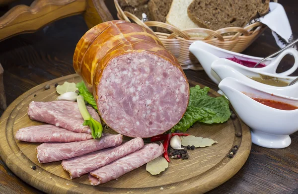 Sausages on a wooden plate — Stock Photo, Image