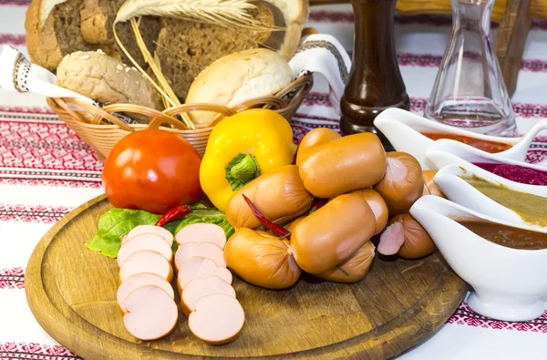 Würstchen auf einem Holzteller — Stockfoto