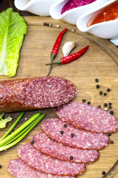 Sausages on a wooden plate — Stock Photo, Image