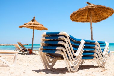 Plajda şemsiye ve şezlonglar