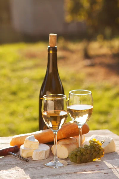 Дві склянки білого вина і пляшки — стокове фото