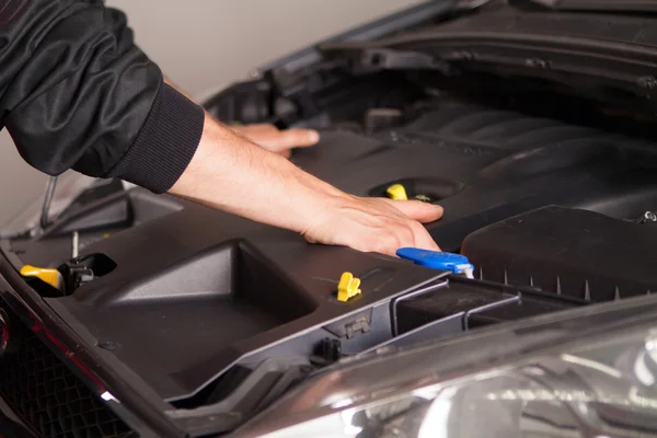 Car mechanic in his repair shop standing next to the car — Stock Photo, Image