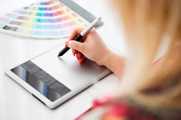 Grafisk formgivare arbetar på en digital tablet och med pantone pa — Stockfoto