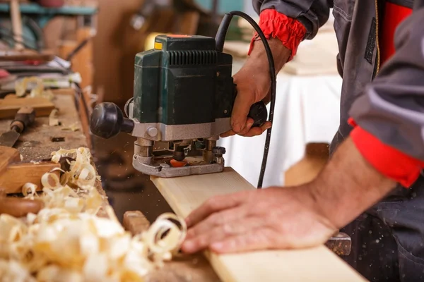 Carpintero en el trabajo con la carpintería cepilladora eléctrica —  Fotos de Stock