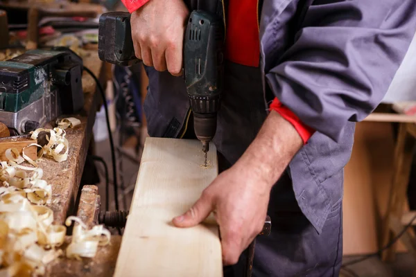 Menuisier au travail avec une perceuse en menuiserie — Photo