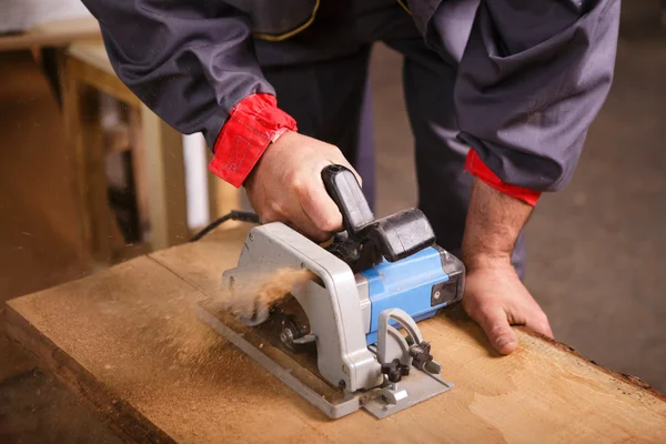 Charpentier des mains travaillant avec une scie circulaire — Photo