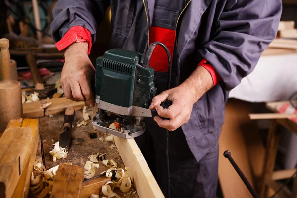 Carpintero en el trabajo con la carpintería cepilladora eléctrica — Foto de Stock