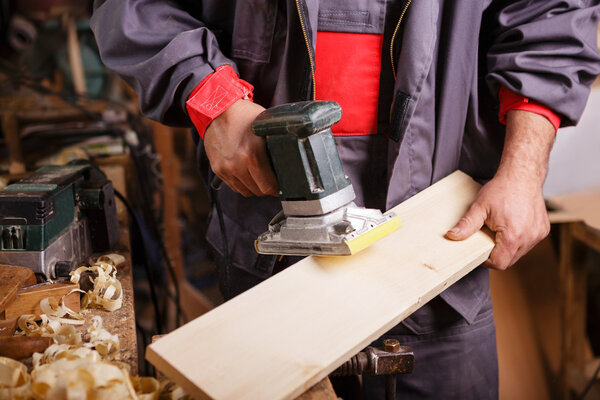 Carpenter at work with the sander